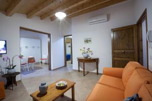 a living room with an orange couch and a table at Vito nel Baglio in Scopello