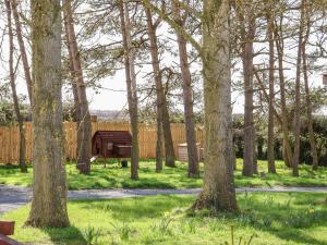 een park met bomen en een houten hek bij Covey in Harpham