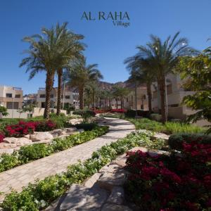 a garden with palm trees and flowers in a resort at Rental unit in alraha village -marsa zayed مرسى زايد- قرية الراحة in Aqaba