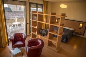 a living room with a book shelf and a bed at Hotel Masini in Forlì