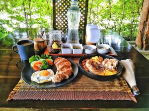 ein Tisch mit zwei Tellern Frühstücksprodukt drauf in der Unterkunft Herbs Guest House and Restaurant near the Sea in Moalboal