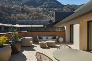a patio with tables and chairs on a balcony at Hotel MIM Andorra in Escaldes-Engordany