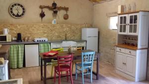 a kitchen with a table and chairs in a kitchen at La Grange de Gournay in  Gournay-Loizé