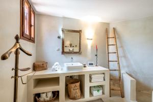 baño con lavabo y espejo en la pared en Villa Kamara, en Kolimvárion