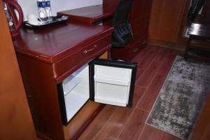 a wooden desk with a small drawer in a room at BWAMI DUBAI HOTEL KASULU 