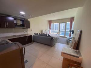 uma ampla sala de estar com um sofá e uma cozinha em Waking up with the sea view! em Dubai