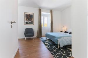 sypialnia z łóżkiem i krzesłem w obiekcie Sintra Flower Lux Apartments w mieście Sintra