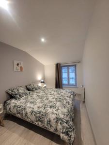 a bedroom with a bed and a window at Appartement Le Duplex in Cluny