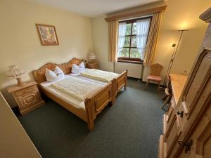 1 dormitorio con cama, mesa y ventana en Hotel Almenrausch en Neukirchen