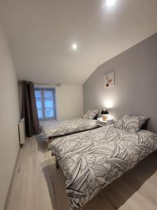 a bedroom with two beds and a window at Appartement Le Duplex in Cluny