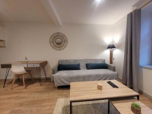 a living room with a couch and a table at Appartement Le Duplex in Cluny