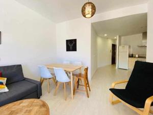 ein Wohnzimmer mit einer Couch und einem Tisch und Stühlen in der Unterkunft Acogedor Apartamento en el Centro de Málaga in Málaga