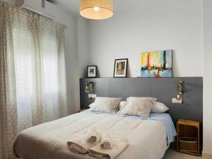 マラガにあるAcogedor Apartamento en el Centro de Málagaのベッドルーム1室(大型ベッド1台、タオル付)