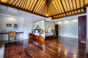 sypialnia z łóżkiem i drewnianą podłogą w obiekcie Villa Atala Seminyak Canggu Umalas XL Pool Maid 4BR w mieście Seminyak