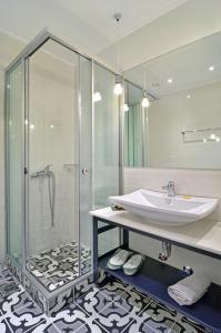 a bathroom with a glass shower and a sink at Z Inn Ioannina in Ioannina