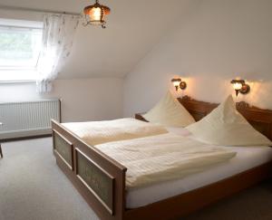 1 dormitorio con 1 cama con sábanas blancas y ventana en Landgasthof Friedrich, en Trebgast