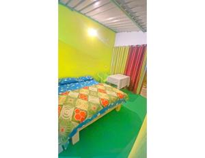 Oakland Camping, Uttarkashi في Uttarkāshi: غرفة نوم مع سرير مع لحاف ملون