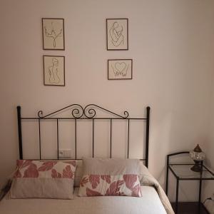 a bedroom with a bed with four pictures on the wall at Estrella Mudejar in Teruel
