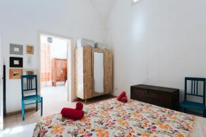 Schlafzimmer mit einem Bett mit roten Stühlen und einem Spiegel in der Unterkunft Nel Cuore del Salento, La Casa del Geco, Elegante Villa d’epoca in Ugento