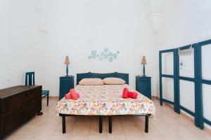 ein Schlafzimmer mit einem Bett mit roten Kissen darauf in der Unterkunft Nel Cuore del Salento, La Casa del Geco, Elegante Villa d’epoca in Ugento