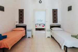 a room with two beds in a room at Nel Cuore del Salento, La Casa del Geco, Elegante Villa d’epoca in Ugento