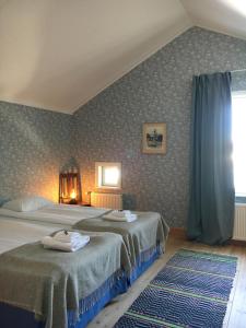 a bedroom with two beds and a window at Brudhäll Hotel & Restaurant in Kökar