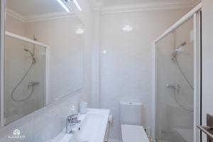 ein weißes Bad mit einem Waschbecken und einer Dusche in der Unterkunft BC Beach House - Santa Cruz in Santa Cruz