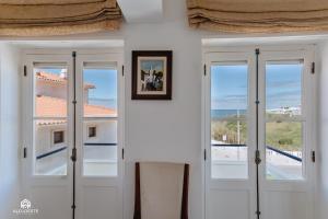 een witte kamer met deuren en uitzicht op de oceaan bij BC Beach House - Santa Cruz in Santa Cruz