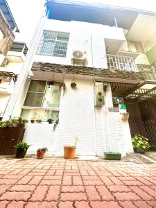 a white house with potted plants in front of it at The Apartment Number 18 in Tainan