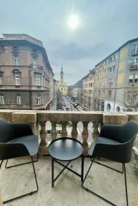 2 sillas y una mesa en un balcón con ciudad en Comfort Lux Design Apartment #Castle #2bedroom #freeparking, en Budapest