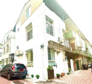 a car parked in front of a white building at The Apartment Number 18 in Tainan