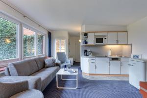 a living room with a couch and a kitchen at Haus Kleemann in Norderney