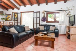 a living room with a leather couch and a coffee table at Casa Angela in Capdepera