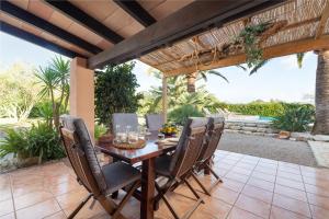 a wooden table and chairs on a patio at Casa Angela in Capdepera