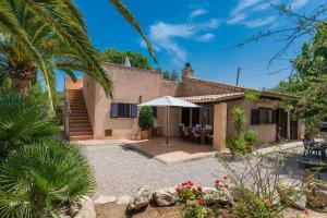 a house with a palm tree and a patio at Casa Angela in Capdepera