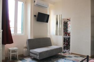 Darsena Suite - Via Argelati في ميلانو: غرفة معيشة فيها كرسي وتلفزيون