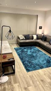 Luxury Top Floor Apartment in London في لندن: غرفة معيشة مع أريكة وسجادة زرقاء