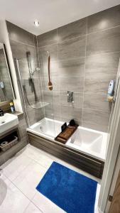 uma casa de banho com um chuveiro, uma banheira e um lavatório. em Luxury Top Floor Apartment in London em Londres