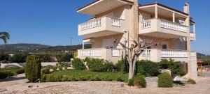 a large white building with a tree in front of it at Evelina's studio in Artemida