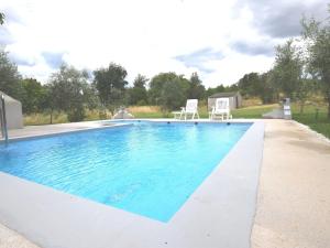 una piscina con acqua blu in un cortile di Apartment in holiday home with pool spacious garden with grill airco and wifi a Banjole