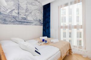 a bedroom with a bed with a painting on the wall at Cozy Nights Letnicka by Renters Prestige in Gdańsk