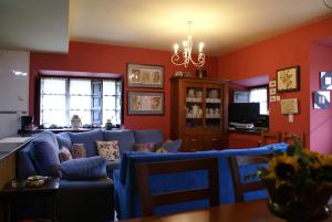 a living room with a blue couch and red walls at La Casa Verde del Sella in Mesariegos