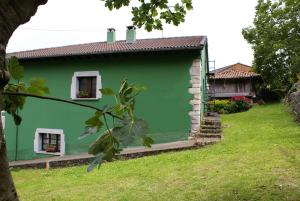 a green house with two windows and a yard at La Casa Verde del Sella in Mesariegos