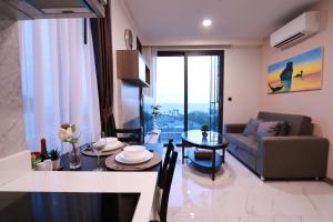 A402-Silk Condo Aonang-Sea view-5 mins walk to beach في شاطيء آونانغ: غرفة معيشة مع أريكة وطاولة