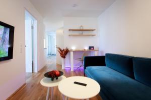 a living room with a blue couch and a table at Wohlfühlapartments in Hard in Hard