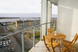 a balcony with a table and chairs and a view of a city at Aalborg limfjorden udsigt in Nørresundby