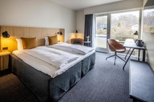 una camera d'albergo con un letto grande e una finestra di Comwell Holte a Holte