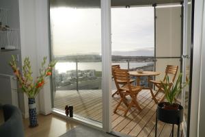 um quarto com uma porta de vidro deslizante e uma mesa em Aalborg limfjorden udsigt em Nørresundby