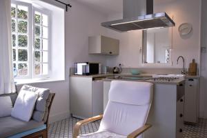 une cuisine avec un comptoir, une chaise et un évier dans l'établissement L'ORANGERIE 3* VUE IMPRENABLE, à Cambo-les-Bains