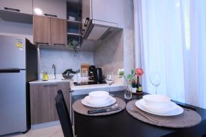 a small kitchen with a table with plates on it at A402-Silk Condo Aonang-Sea view-5 mins walk to beach in Ao Nang Beach